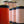 A close-up row of cylindrical tins with pale blush pink labels and dark navy bands, some with gold tops. The foreground tins are in sharp focus while those behind them blur softly due to shallow depth of field.