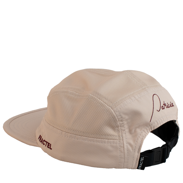 The back of a light pink running cap with the Patricia logo embroidered in maroon on the back, and Fractel on the left panel.