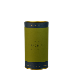 A navy blue cylinder with a green label describes the roasted coffee beans within. 'PATRICIA' and 'TWO HUNDRED GRAMS' are printed in gold foil.
