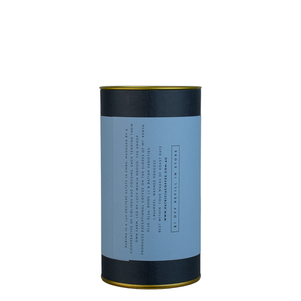 A navy blue cylinder with a blue label describes the roasted coffee beans within.