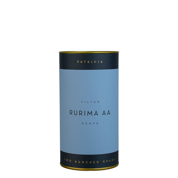 A navy blue cylinder with a blue label describes the roasted coffee beans within. 'PATRICIA' and 'TWO HUNDRED GRAMS' are printed in gold foil.