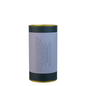 A navy blue cylinder with a violet label describes the roasted coffee beans within.