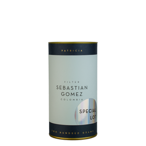 A navy blue cylinder with a light blue label describes the roasted coffee beans within. 'PATRICIA' and 'TWO HUNDRED GRAMS' are printed in gold foil. A shiny round sticker reads 'SPECIAL LOT'