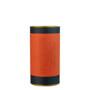 A navy blue cylinder with a red label describes the roasted coffee beans within.