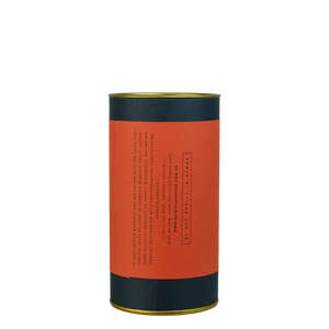 A navy blue cylinder with a red label describes the roasted coffee beans within.