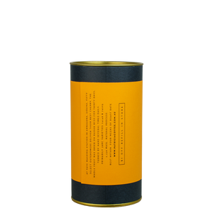 A navy blue cylinder with an orange label describes the roasted coffee beans within.