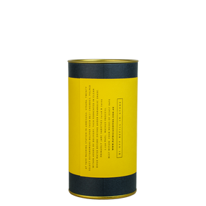 A navy blue cylinder with a yellow label describes the roasted coffee beans within.