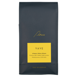 A navy blue recyclable bag containing 1kg of specialty coffee beans. It has the Patricia logo in gold, the coffee's name on a yellow sticker, and 'One kilogram' in gold underneath.